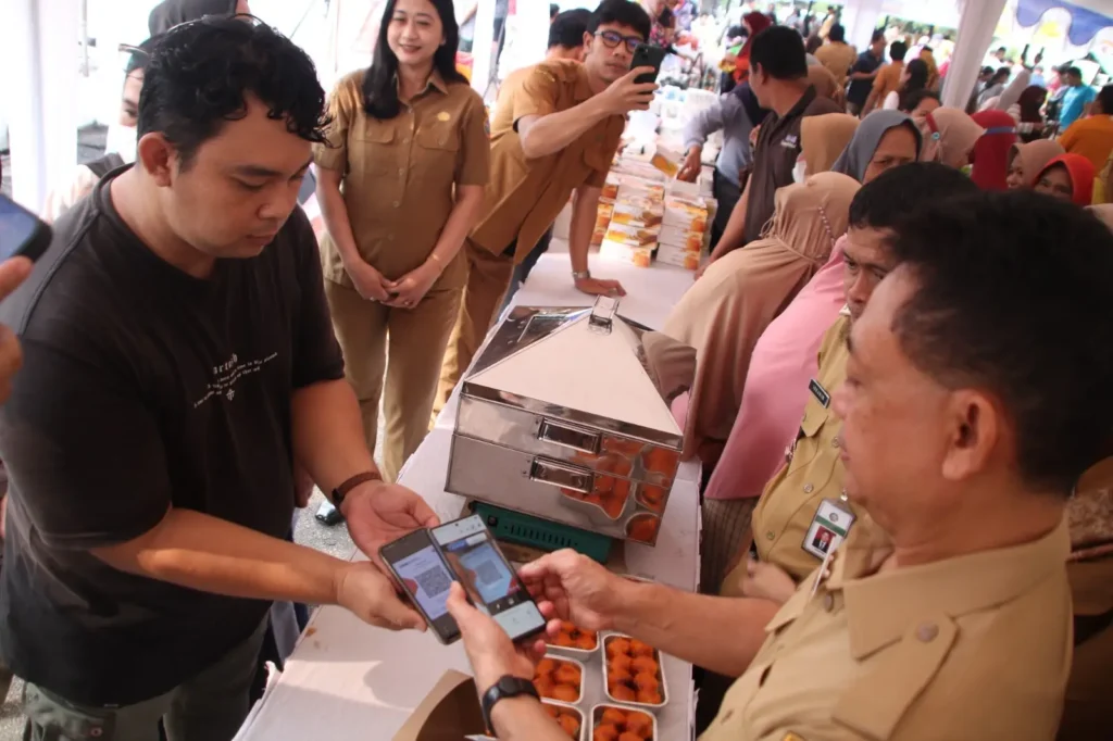 Wali Kota Pontianak Edi Rusdi Kamtono saat bertransaksi menggunakan QRIS pada salah satu pelaku UMKM di pasar murah di Kantor Camat Pontianak Selatan, Selasa (20/10/2026).