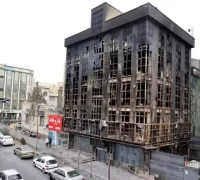 Warga berjalan melewati bangunan yang terbakar dan rusak parah akibat protes massa di Teheran, Iran, 19 Januari 2026.