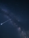 573463de-6f2e-4556-9c21-d78e2c797924 Ilustrasi hujan meteor Orionid melintas di langit malam yang gelap dengan gugusan bintang Orion sebagai latar