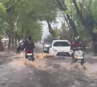 Genangan banjir merendam Jalan Perdana Pontianak akibat hujan deras dan air pasang Sungai Kapuas yang terjadi bersamaan.