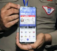 SIM digital melalui aplikasi Digital Korlantas di smartphone saat pemeriksaan oleh petugas kepolisian.
