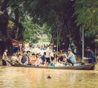 Warga dan wisatawan menaiki perahu melintasi kawasan kota tua Hoi An, Vietnam, yang masih tergenang banjir. (x.com/TheCBIJ)