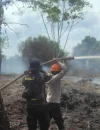 Personel Polres Kubu Raya bersama tim gabungan memadamkan kebakaran hutan dan lahan di Kecamatan Rasau Jaya, Kabupaten Kubu Raya.