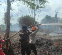 Personel Polres Kubu Raya bersama tim gabungan memadamkan kebakaran hutan dan lahan di Kecamatan Rasau Jaya, Kabupaten Kubu Raya.