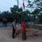 Polsek Sungai Ambawang membagikan dan membantu memasang Bendera Merah Putih di rumah warga menjelang HUT ke-81 RI.