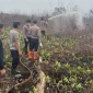 Polisi melakukan pendinginan bekas karhutla di Desa Limbung Kubu Raya. (Foto: Res-KKR)