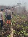 Polisi melakukan pendinginan bekas karhutla di Desa Limbung Kubu Raya. (Foto: Res-KKR)