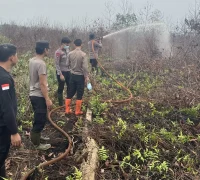 Polisi melakukan pendinginan bekas karhutla di Desa Limbung Kubu Raya. (Foto: Res-KKR)