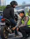 Ilustrasi razia knalpot brong di Pontianak dengan petugas Satlantas memeriksa sepeda motor pelanggar aturan lalu lintas.