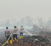 Personel Brimob melakukan pendinginan lahan gambut bekas terbakar di Rasau Jaya, Kubu Raya. (Res-KKR)