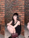 Karina aespa tampil anggun mengenakan gaun hitam tanpa lengan dengan latar dinding bata merah. (foto: instagram.com/katarinabluu)