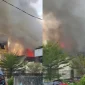 Kebakaran di kawasan Jalan Tanjungpura Pontianak dengan kepulan asap hitam saat petugas pemadam berupaya menjinakkan api.