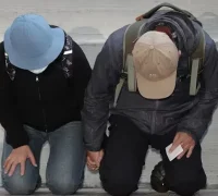 Orang tua pelaku penusukan massal Metro Taipei berlutut meminta maaf di rumah duka. (Dok. AFP)