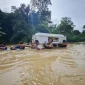 Petugas bersama warga menggotong peti jenazah menembus banjir di Beduai, Sanggau. (Dok. Nuansa Kalbar)