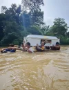 Petugas bersama warga menggotong peti jenazah menembus banjir di Beduai, Sanggau. (Dok. Nuansa Kalbar)