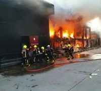 Petugas pemadam kebakaran dan tim penyelamat mengevakuasi korban di lokasi kebakaran pub di Bangkok, Thailand.