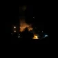 Asap membumbung setelah serangan udara dalam eskalasi konflik antara Amerika Serikat dan Iran di kawasan Timur Tengah.