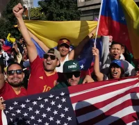 Warga Venezuela di luar negeri merayakan jatuhnya Nicolas Maduro dengan mengibarkan bendera nasional. (REUTERS/Leonardo Fernandez Viloria)