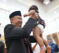 Wali Kota Pontianak Edi Rusdi Kamtono menggendong balita sebelum ditimbang berat badannya dalam kegiatan imunisasi anak.