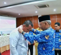Sekretaris Daerah Kota Pontianak Amirullah mengalungkan tanda peserta pelatihan peningkatan kompetensi SDM KDKMP.