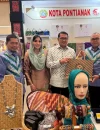 Asisten Administrasi Umum Setda Kota Pontianak, Yusnaldi menyerahkan cenderamata kepada Menteri Ekonomi Kreatif Teuku Riefky Harsya saat mengunjungi stan Kota Pontianak.