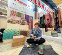 Natalia Desca Rina, perajin asal Pontianak tengah membuat sandal kulit di stand INACRAFT Jakarta.