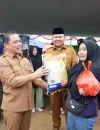 Gubernur Kalbar Ria Norsan menyerahkan paket sembako pasar murah kepada warga di Halaman Masjid Agung Kota Juang Melawi, Selasa (25/2/2026).