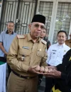 Sekretaris Daerah Kota Pontianak Amirullah menyerahkan secara 1 pak telur kepada Saripin (81), warga Pontianak Tenggara yang berbelanja di Operasi Pasar Murah.