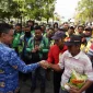 Wali Kota Pontianak Edi Rusdi Kamtono menyerahkan bantuan beras kepada Deris Landuk, penambang sampan tradisional.