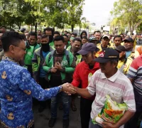 Wali Kota Pontianak Edi Rusdi Kamtono menyerahkan bantuan beras kepada Deris Landuk, penambang sampan tradisional.