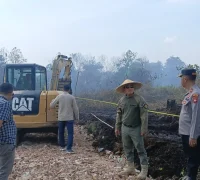 Polisi memasang garis polisi di lokasi lahan terbakar di Sungai Raya Kubu Raya, (26/3/2026).