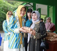 Ketua TP PKK Kota Pontianak Yanieta Arbiastutie menyerahkan secara simbolis telur ayam kepada warga yang berbelanja di bazar murah telur.