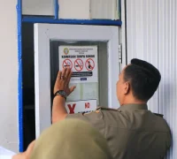 Tim Satgas Kawasan Tanpa Rokok (KTR) tengah menempelkan tanda larangan merokok sebagai implementasi Perda Nomor 4 Tahun 2025 tentang KTR.