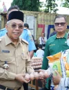 Sekretaris Daerah Kota Pontianak Amirullah menyerahkan paket sembako kepada pembeli pertama Operasi Pasar Jelang Iduladha di halaman Kantor Camat Pontianak Barat, Selasa (19/5/2026).