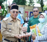 Sekretaris Daerah Kota Pontianak Amirullah menyerahkan paket sembako kepada pembeli pertama Operasi Pasar Jelang Iduladha di halaman Kantor Camat Pontianak Barat, Selasa (19/5/2026).
