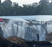 Petugas pemadam kebakaran berupaya memadamkan api yang melahap rumah panjang di Kampung Labau, Sarawak menjelang perayaan Hari Gawai.