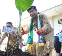 Plh Kepala Dinas Lingkungan Hidup Kota Pontianak, Muchammad Yamin, melakukan penanaman pohon secara simbolis saat peluncuran Program Digulis Ceria di SMPN 8 Pontianak.