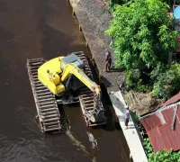 Dinas PUPR Kota Pontianak menerjunkan eskavator amfibi untuk mengeruk parit agar memperlancar aliran air.