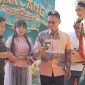 Wali Kota Pontianak Edi Rusdi Kamtono menyerahkan bakcang kepada warga dalam Festival 1.000 Bakcang Pontianak di Taman Alun Kapuas, Jumat (19/6/2026). Dalam festival ini turut dibagikan 1.000 bakcang gratis kepada para pengunjung.
