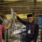 ⁠Sekretaris Daerah Kota Pontianak Amirullah memperlihatkan ikan bersama pemilik gudang.