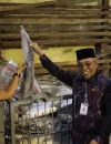 ⁠Sekretaris Daerah Kota Pontianak Amirullah memperlihatkan ikan bersama pemilik gudang.