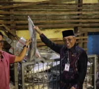 ⁠Sekretaris Daerah Kota Pontianak Amirullah memperlihatkan ikan bersama pemilik gudang.