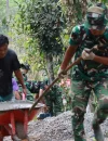 Anggota Satgas TMMD bersama warga menarik arko bermuatan material menggunakan kayu bercabang di medan terjal Desa Watuduwur, Purworejo.