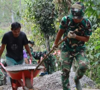 Anggota Satgas TMMD bersama warga menarik arko bermuatan material menggunakan kayu bercabang di medan terjal Desa Watuduwur, Purworejo.