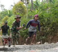 Satgas TMMD bersama warga menarik arko berisi material saat melintasi medan terjal untuk mendukung pengecoran jalan di Desa Watuduwur, Purworejo.