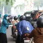 Ketua TP PKK Kota Pontianak membagikan masker kepada pengendara sepeda motor di kawasan bundaran Tugu Digulis Untan, Rabu (19/8/2026).