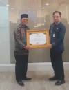 Kepala Bapperida Pontianak Yuli Trisna Ibrahim menerima plakat penghargaan Terbaik I Indeks Pengelolaan Keuangan Daerah klaster fiskal sangat tinggi di Kantor Bapperida Kalbar, Kamis (27/8/2026).