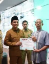 Wakil Wali Kota Pontianak Bahasan menyerahkan penghargaan kepada pedagang tercepat melakukan pembayaran retribusi pasar saat peluncuran SI PATUH PASAR di Pontive Center, Selasa (22/9/2026).