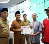 Wakil Wali Kota Pontianak Bahasan menyerahkan penghargaan kepada pedagang tercepat melakukan pembayaran retribusi pasar saat peluncuran SI PATUH PASAR di Pontive Center, Selasa (22/9/2026).