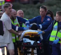 Petugas medis mengevakuasi korban penembakan di Pantai Bondi, Sydney. (Mark Baker/AP)